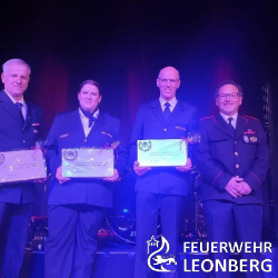 Am 30. Juni war es so weit. Unser gemeinsames Feuerwehrfest stand in den Startl&ouml;chern. Am Freitagabend haben wir unser internen Feuerwehrabend gehabt. Die Steigwaldhalle wurde dabei feierlich und idyllisch mit Rollschl&auml;uchen, alten Feuerwehrhelmen, riesigen Musiknoten und roten 112-Papptafeln zum Feuerwehrgeschehen geschm&uuml;ckt. Neben der gro&szlig;en B&uuml;hne war noch ein historischer Hydrantenwagen aufgestellt, welcher bis 1960 in Warmbronn im Einsatz war. 

Der Festakt wurde durch unseren Schalmeienzug er&ouml;ffnet. Gesamtkommandant Wolfgang Zimmermann hatte das erste Wort am Mikro und begr&uuml;&szlig;te nicht nur die Feuerwehr Leonberg, sondern auch unsere Feuerwehrpartner aus Kaltern (S&uuml;dtirol) und Rovinj (Kroatien), die extra f&uuml;r unser gro&szlig;es und gemeinsames Jubil&auml;um den weiten Weg nach Warmbronn gefunden hatten. Auch die anderen Blaulichtorganisationen wie THW, DLRG, Polizei, sowie die Kommandanten der Feuerwehren Weil der Stadt und Werkfeuerwehr Bosch waren an diesem Abend vertreten. Zudem waren auch einige Ehreng&auml;ste wie Oberb&uuml;rgermeister Martin Georg Cohn an diesem Abend anwesend. Dieser sprach Gru&szlig;worte an die verschiedenen Jubil&auml;umsabteilungen. Gegen Ende seiner Rede &uuml;bergab der Oberb&uuml;rgermeister dem Abteilungskommandanten Simon Mayer einen riesigen Feuerwehrkuchen im Design eines Feuerwehrautos. 

Musikalisch wurde der Abend zwischen den Reden von unserem Schalmeienzug begleitet. Als n&auml;chstes wurden nat&uuml;rlich von den Jubil&auml;umsabteilungen eine Festrede gehalten. Simon Mayer von der Abteilung Warmbronn, Sandra Kugel von der Jugendfeuerwehr und Klaus M&ouml;rk vom Schalmeienzug. Auch Thomas Butsch vom Kreisfeuerwehrverband B&ouml;blingen hatte ebenfalls ein paar nette Worte an uns gerichtet. Als letzter Redner sprach der Leiter der Altersab-teilung Martin Tr&ouml;scher, welcher auch den gem&uuml;tlichen Teil des Abends eingeleitet hat. 

Begonnen mit dem gem&uuml;tlichen Teil hat der LinkMichel - Die schw&auml;bische Schwertgosch. Nach seinem erfolgreichen Comedyauftritt gab es f&uuml;r die Feuerwehr Leonberg einen Musikauftritt der Band The UnderCover Project. Die Feuerwehr lie&szlig; sich da auch nicht lumpen und feierte auch hier gemeinsam in in die Nacht hinein. Die Bewirtung &uuml;bernahm die Narrenzunft Beerlesklopfer. Vielen Herzlichen Dank f&uuml;r euren Einsatz. 



Partynacht mit den Blaumeisen
Um 18:30 Uhr &ouml;ffneten sich die Tore der Steigwaldhalle in Warmbronn und empfingen die ersten G&auml;ste, die sich bereits auf die Party mit der Band Blaumeisen um 20:30 Uhr vorbereiteten. Besonderes Augenmerk lag auf der detailverliebten Dekoration und der frisch gestalteten B&uuml;hne, die im Verlauf des Tages aufgebaut worden waren. Die Bewirtung wurde von unseren eigenen Mitgliedern &uuml;bernommen und bot den G&auml;sten eine reichhaltige Auswahl an Speisen und Getr&auml;nken, die gro&szlig;en Anklang fand. Die exklusive Florie-Bar, die an diesem Abend erstmals ihre Pforten &ouml;ffnete, wurde bereits zur Er&ouml;ffnung frequentiert. 

Dann war der Moment gekommen: Die Lichtershow begann und die ersten Kl&auml;nge der Blaumeisen er&ouml;ffneten die Party. Rasch erhoben sich die Anwesenden von ihren Pl&auml;tzen und begaben sich zur Tanzfl&auml;che vor der B&uuml;hne, um ausgelassen zu tanzen und zu feiern. Die Nacht brach herein, und die Blaumeisen heizten dem Saal weiter kr&auml;ftig ein. Ihr letzter Song erklang um 0:30 Uhr, und gegen 1 Uhr lichtete sich allm&auml;hlich der Saal. Doch die Feier war damit noch nicht vorbei, denn die Florie-Bar lud weiterhin zu guter, lauter Musik ein. Die G&auml;ste sangen und tanzten ausgelassen bis in die fr&uuml;hen Morgenstunden. Gegen 2 Uhr hie&szlig; es schlie&szlig;lich, Abschied von unseren G&auml;sten zu nehmen.



Der Feuerwehr Familientag
Fr&uuml;hmorgens wurde der Altar liebevoll geschm&uuml;ckt, und J&uuml;rgen Oettel leitete einen Gottesdienst im Freien. Nebenbei wurden verschiedene Fahrzeuge ausgestellt, darunter au&szlig;er Dienst gestellte Drehleitern aus Leonberg und Esslingen, das THW, die Werkfeuerwehr Mercedes-Benz aus Sindelfingen mit ihrem L&uuml;fter 2 f&uuml;r schnelle Entl&uuml;ftung gro&szlig;er Fabrikhallen, sowie die Werkfeuerwehr Bosch aus Reutlingen mit ihrem Universall&ouml;schfahrzeug (ULF). Selbstverst&auml;ndlich war auch die Feuerwehr Leonberg mit ihrem Wechselladerfahrzeug (WLF), AB-Hygiene, AB-Tunnel, TLF 3000 und Luftunterst&uuml;tzungsfahrzeug (LUF 60) vertreten. 

Der Schalmeienzug der Feuerwehr Leonberg leitete mit zwei Liedern aus dem Gottesdienst heraus und trat dann erneut um 11:30 Uhr f&uuml;r die Besucher des Familientags auf. Parallel dazu wurde eine Spielstra&szlig;e mit H&uuml;pfburg f&uuml;r die j&uuml;ngsten G&auml;ste aufgebaut, um ihnen eine spielerische Besch&auml;ftigung zu bieten. 

Um 13:30 Uhr f&uuml;hrte die Jugendfeuerwehr auf dem Schulhof eine kleine Brand&uuml;bung vor. Es war eine Herausforderung, aufgrund der aktuellen Wetter- und Trockenbedingungen &uuml;berhaupt eine Brandsimulation durchzuf&uuml;hren, da bereits der kleinste Funken ein Risiko im nahen Wald darstellen k&ouml;nnte. Dank spezieller Auflagen wie einer zus&auml;tzlichen Brandschutzplattform und zus&auml;tzlichem Wasservorrat konnten wir schlie&szlig;lich bedenkenlos das Brandobjekt f&uuml;r die Kinder anz&uuml;nden. Das LF8 der Jugendfeuerwehr eilte herbei und l&ouml;schte die Gartenh&uuml;tte mit drei C-Rohren. Das Publikum zeigte sich beeindruckt, da nicht nur das Feuer gel&ouml;scht, sondern auch der ein oder andere Kamerad erfrischt wurde. 

Zus&auml;tzlich zur Open-Air-Bewirtung gab es in der Steigwaldhalle Kaffee und Kuchen, serviert vom Schalmeienzug. Um 14 Uhr spielte der Musikverein Lyra aus Leonberg und unterhielt die Zuschauer bis zur n&auml;chsten gro&szlig;en Vorf&uuml;hrung. Die Kameraden aus H&ouml;fingen zeigten diese und demonstrierten einen Tunnelbrand mit dem LUF-Zug. Dieser LUF-Zug in Leonberg besteht aus einem HLF 20, einem TLF 3000 und dem Ab-Tunnel, in dem das L&ouml;sch-Unterst&uuml;tzungs-Fahrzeug 60 untergebracht ist. Das 140 PS starke Fahrzeug wurde aus dem Ausstellungsraum voll ausger&uuml;stet zur &Uuml;bungsfahrt zum &Uuml;bungsobjekt gebracht. Moritz Sch&auml;fer erl&auml;uterte den Ablauf der &Uuml;bung und die Geschehnisse in einem Tunnel. Unsere erfolgreiche Tunneltaktik, die wir in der Schweiz erlernt hatten, wurde hier im Freien eindrucksvoll demonstriert. Dank des feinen Spr&uuml;hnebels freuten sich sowohl Kinder als auch Erwachsene &uuml;ber die erfrischende K&uuml;hle.

Nach der LUF-&Uuml;bung fand auf der Festwiese eine Preisverleihung f&uuml;r einen Malwettbewerb statt, an dem Kinder aus Kinderg&auml;rten und Grundschulen teilgenommen hatten. Die strahlenden Gewinner freuten sich &uuml;ber Helme und Spielzeugautos. An die Kinder, die nicht anwesend waren, aber Preise gewonnen hatten, versicherten wir, dass sie ihre Preise nachtr&auml;glich pers&ouml;nlich erhalten w&uuml;rden. Im Hintergrund machte sich der Spielmannszug der Freiwilligen Feuerwehr Leinfelden-Echterdingen bereit, um zu spielen. Um 17:15 Uhr wurde schlie&szlig;lich die letzte Vorf&uuml;hrung des Tages gezeigt. Die Abteilung Gebersheim pr&auml;sentierte dem Publikum einen Verkehrsunfall und das Vorgehen bei einem solchen Szenario. Das HLF 10 r&uuml;ckte mit Blaulicht und Sondersignal zur Unfallstelle aus. Der Gruppenf&uuml;hrer erkundete die Situation und erkannte schnell, dass ein PKW die Kontrolle verloren hatte und unter einem Traktoranh&auml;nger festsa&szlig;. Die Besatzung sicherte das Fahrzeug und den Anh&auml;nger, um ein Wegrollen zu verhindern, und schuf einen gesch&uuml;tzten Bereich f&uuml;r sich und den Patienten. W&auml;hrend dieser Sicherungsphase wurde der Brandschutz gew&auml;hrleistet und ein Bereitstellungsraum eingerichtet. Ein Zugang zum Fahrzeug wurde geschaffen, um dem inneren Retter den Zugang zum Patienten zu erm&ouml;glichen. Danach wurde das Auto systematisch in Einzelteile zerlegt, um den Patienten achsengerecht zu befreien. Nach erfolgreicher Rettung &uuml;bergaben die Kameraden den Patienten dem Rettungsdienst. Damit endete die &Uuml;bung, und die Kollegen aus Gebersheim r&uuml;steten ihr Fahrzeug wieder auf und genossen den verbleibenden Festabend. Das Fest endete gegen 19 Uhr, gefolgt von Abbauarbeiten.

Die Feuerwehr Leonberg und alle Abteilungen bedanken sich f&uuml;r eure Unterst&uuml;tzung und f&uuml;r euren Besuch an unserem Festwochenende. Wir hoffen ihr hattet angenehme Tage und viel Spa&szlig;. Wir freuen uns euch bald wieder zu sehen und w&uuml;nschen euch bis dahin einen angenehmen Sommer.